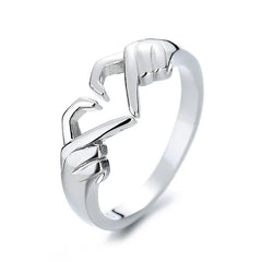 A silver-colored adjustable ring featuring two hands forming a heart shape.