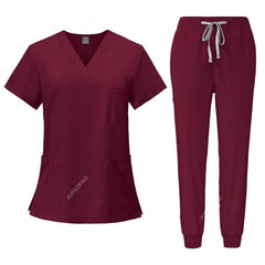 A burgundy women's scrub set featuring a V-neck top with pockets and matching jogger pants.