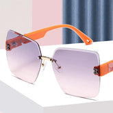 Rimless square sunglasses with gradient pink lenses and orange plastic temples featuring an H logo.