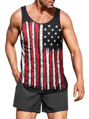 A man wears a black tank top featuring a distressed American flag print and dark grey shorts.