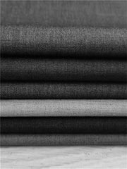 A stack of folded fabric swatches in various shades of grey and black.