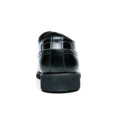 A rear view of a black leather brogue dress shoe with a thick rubber sole.