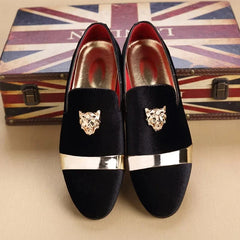 Black velvet slip-on loafers for men featuring a gold lion head emblem and a metallic toe accent.