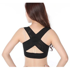 A woman wearing a black, crisscross-strap posture corrector brace on her upper back.