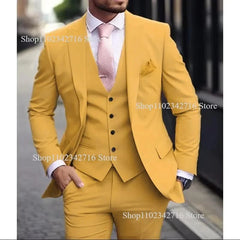 A man wears a slim-fit mustard yellow three-piece suit with a white shirt and a pink tie.