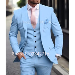 A man wears a light blue three-piece suit with a white shirt and a pink tie.