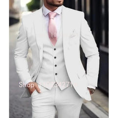 A man wearing a slim-fit white three-piece suit with a light pink tie for a formal occasion.