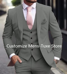 A man wears a slim-fit grey three-piece suit with a white shirt and a pink tie.