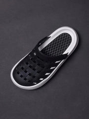 A black closed-toe sandal with a woven upper and a thick white platform sole.