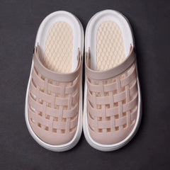 A pair of light pink platform clogs with a woven-style upper and white soles.
