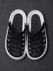 A pair of black closed-toe sandals with a woven upper and a thick white platform sole.