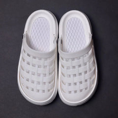 A pair of white platform clogs with a woven-style upper and a textured footbed.