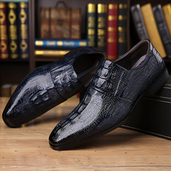 A pair of dark blue slip-on dress shoes with a glossy crocodile-embossed texture.
