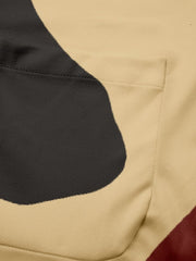 A close-up of a tan suit jacket featuring a dark abstract digital print and a chest pocket.