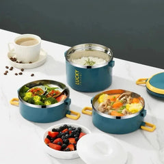 Three round, teal-colored stainless steel bento lunch boxes are arranged on a white surface.