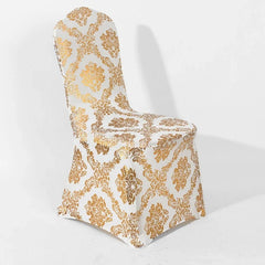 A white spandex chair cover featuring a metallic gold damask print pattern.