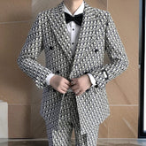 A man wearing a slim-fit, double-breasted suit with a black and white monogram print.