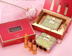 A set of three lipsticks displayed next to a gold glittery handbag-shaped case in a red gift box.
