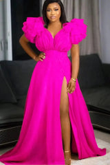 A woman wears a floor-length, hot pink A-line dress with a deep V-neck and ruffled puff sleeves.