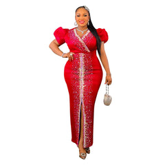 A woman wears a red, ankle-length, V-neck bodycon dress with puff sleeves and rhinestone detailing.
