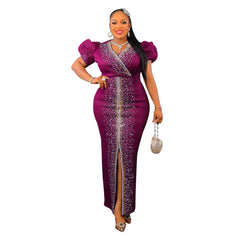 A woman wears a long, purple, V-neck bodycon dress with puff sleeves and rhinestone embellishments.