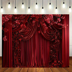A red curtain backdrop featuring draped fabric and floral accents with hanging light bulbs above.