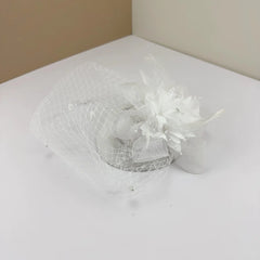A white bridal fascinator featuring a mesh veil, decorative feathers, and small pearl accents.