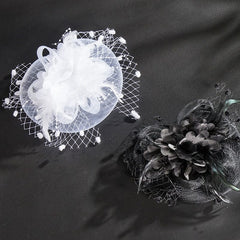 Two retro-style fascinator headpieces with feathers and netting in white and black.