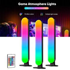 Three vertical RGB light bars with stands and a remote control on a gaming desk background.