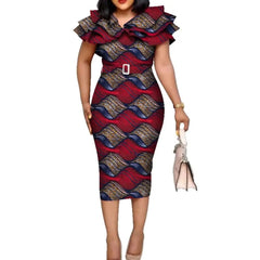 A woman wears a knee-length, red and blue patterned African print dress with a ruffled collar and belt.