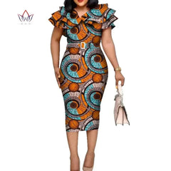 A woman wears a knee-length African print dress with a ruffled collar and a matching belt.