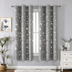 Two grey blackout curtains featuring a silver star and moon pattern with metal grommets.
