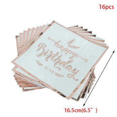 A stack of sixteen square white paper napkins with rose gold happy birthday text and leaf accents.