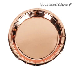 A round, disposable paper plate with a shiny, metallic rose gold finish.