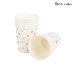 A stack of white paper cups decorated with a rose gold polka dot pattern.