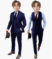 A young boy models a royal blue three-piece suit set including a jacket, vest, and trousers.