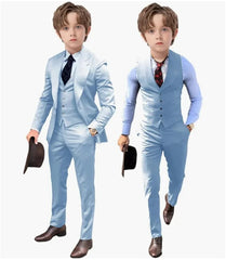 A young boy models a light blue three-piece suit set consisting of a blazer, vest, and trousers.