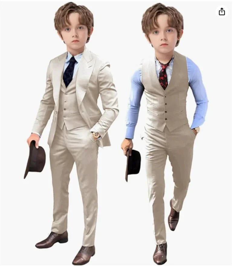 A young boy models a beige three-piece suit set consisting of a blazer, vest, and trousers.
