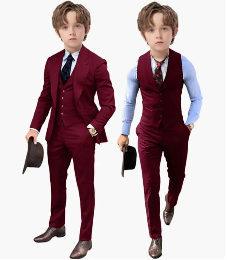 A young boy models a burgundy three-piece suit with a matching vest, trousers, and jacket.