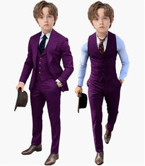 A young boy models a three-piece purple suit set consisting of a blazer, vest, and trousers.