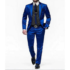 A man wears a royal blue satin two-piece suit with a black polka dot shirt and a black tie.