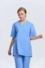 A woman wearing a light blue V-neck medical scrub top and matching pants.