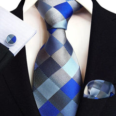 A men's necktie, pocket square, and cufflink set featuring a blue and grey checkered pattern.