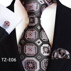 A black necktie, pocket square, and cufflink set featuring a geometric floral jacquard pattern.