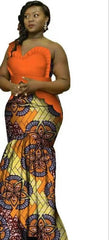 A woman wears a long, one-shoulder dress featuring an orange bodice and a patterned skirt.