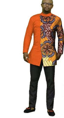 A man wears a long-sleeved orange shirt with a patterned African print panel and black trousers.