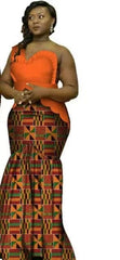 A woman wears a long, fitted dress featuring a bright orange one-shoulder bodice and a patterned skirt.
