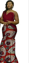 A woman wears a long, sleeveless, red mermaid-style dress featuring a patterned wax cotton print.