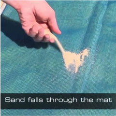 A hand pours sand onto a blue mesh beach mat, demonstrating how the sand falls through the fabric.