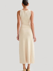 A woman from behind wears a sleeveless, apricot-colored ribbed knit maxi dress.